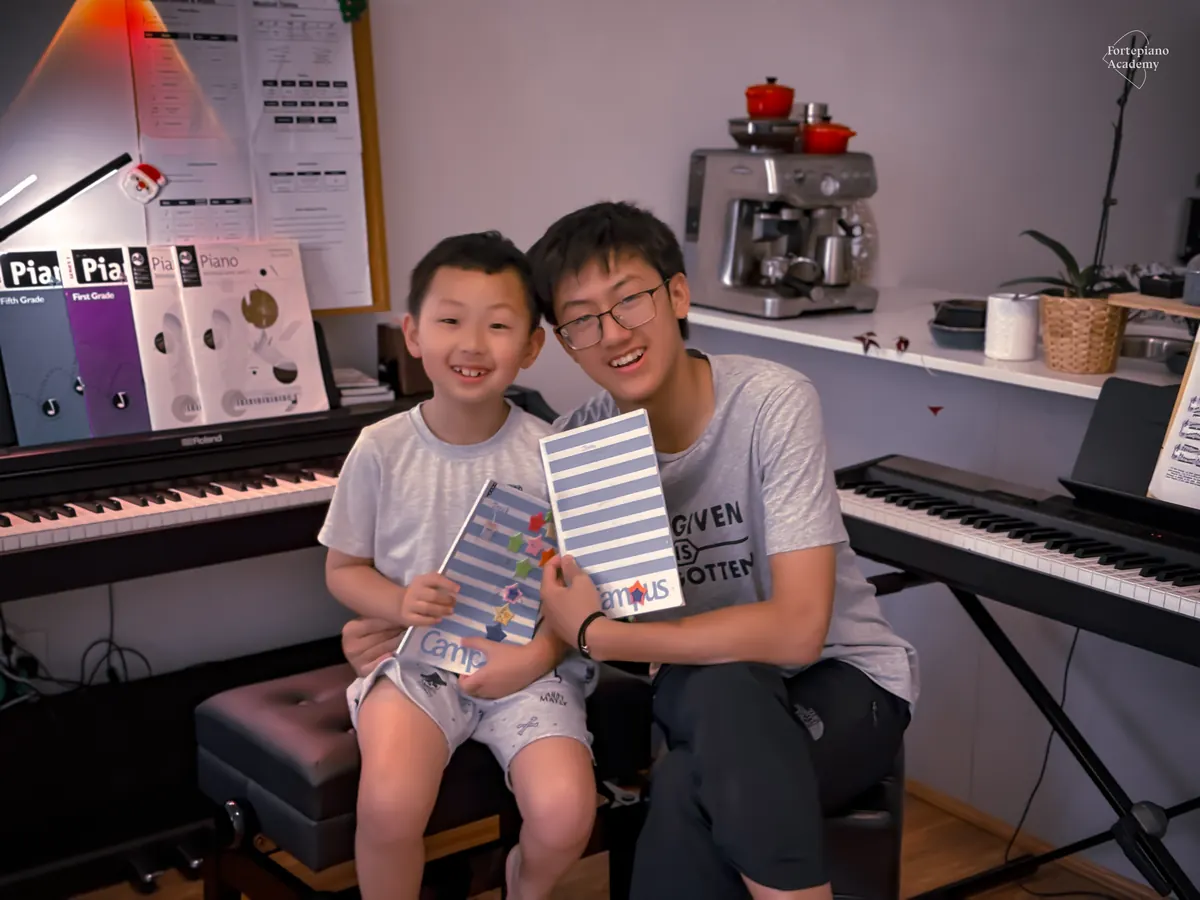 Fortepiano Academy students holding their practice diaries in the studio